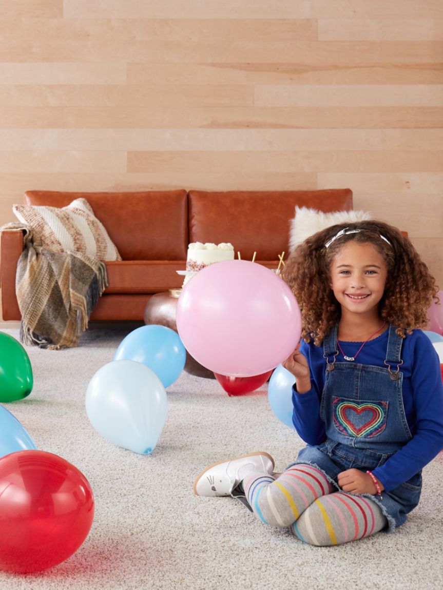 Dad pushing Daughter in Cardboard Box on Hardwood Floors